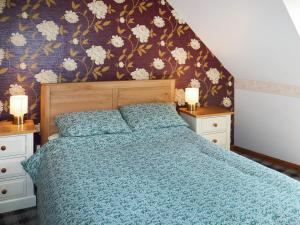 a bedroom with a bed with a blue comforter at Weaver's Cottage in Banchory