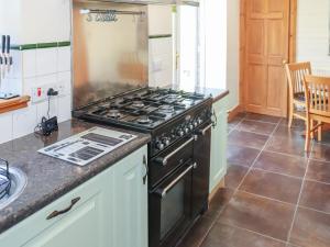 a kitchen with a stove and a counter top at Weaver's Cottage in Banchory
