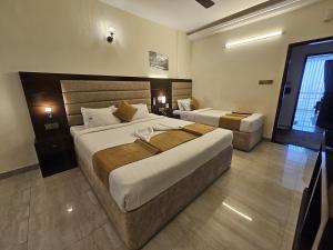 ein Hotelzimmer mit zwei Betten und einem Fenster in der Unterkunft White Park Hotel & Suites in Chittagong