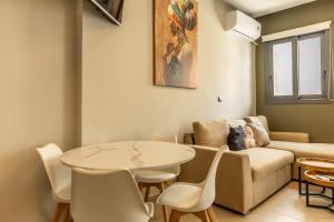 a living room with a couch and a table and chairs at Baja Suites in Kalamata