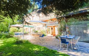 a patio with tables and chairs in front of a building at Logis Hôtel Auberge de la Hulotte in Saint-Jacques-dʼAmbur