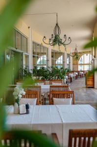 a dining room with tables and chairs and a chandelier at Lighthouse Golf & Spa Hotel - Mineral Pools, Premium All Inclusive, SPA & Beach Access, Free Parking in Balchik