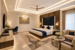 a hotel room with a bed and a desk at Hotel Prak Tree Sector 20 Noida in Noida