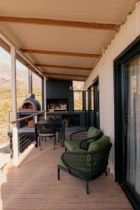 a porch with chairs and a fireplace on a house at untether on Olive View in Wellington