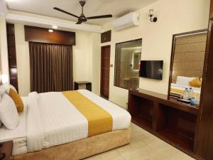 ein Hotelzimmer mit Bett und Fernseher in der Unterkunft White Park Hotel & Suites in Chittagong