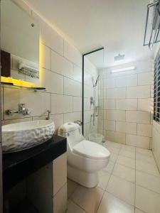 ein weißes Badezimmer mit Waschbecken und Toilette in der Unterkunft White Park Hotel & Suites in Chittagong + 31 Fotos