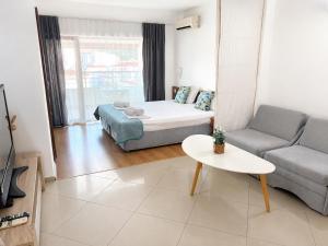 a living room with a bed and a couch and a table at Tabanov Beach Hotel in Sozopol
