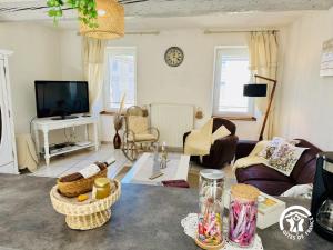a living room with a couch and a tv at Le carpe diem in Pomas