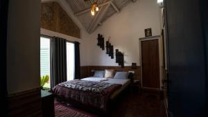 a bedroom with a bed and a large window at The Chill Inn ''Families Only'' By Green Leaves in Ooty