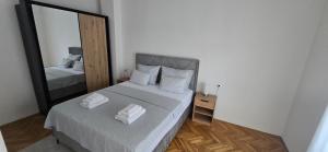 a bedroom with a large mirror and a bed at Apartman-Zara m in Zadar
