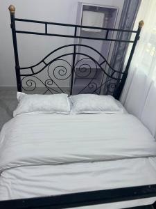 a bed with a black headboard and two white pillows at Rv delight suite in Nairobi
