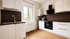 a kitchen with white cabinets and a window at Maison Luma in Basse-Yutz