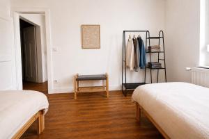 a room with two beds and a chair in it at Maison Luma in Basse-Yutz
