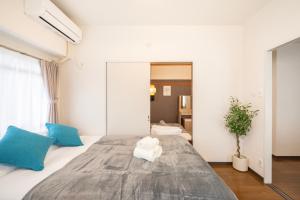 a bedroom with a large bed with blue and white pillows at CS Residence Chiba in Chiba