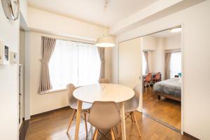a dining room with a table and chairs and a bed at CS Residence Chiba in Chiba +6 photos