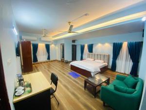 ein Schlafzimmer mit einem Bett, einer Couch und einem Tisch in der Unterkunft Ocean Residence in Chittagong