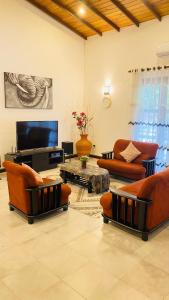a living room with couches and a flat screen tv at Villa Mistora in Kandy