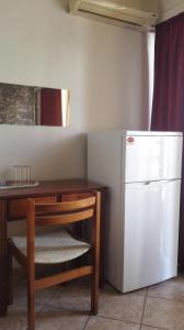 a kitchen with a table and a white refrigerator at Hotel Ionion in Piraeus