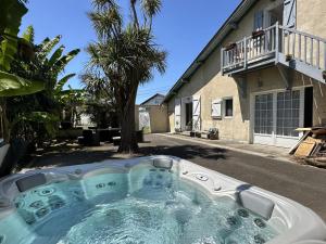 a hot tub in front of a house at Maison le baron in Bélus