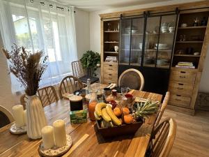 a dining room table with a basket of fruits and vegetables at Maison le baron in Bélus