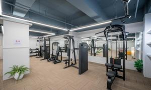 a gym with several treadmills and elliptical machines at Dongdaegu Station Eastern Hotel in Daegu