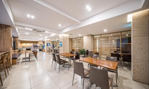a restaurant with tables and chairs in a room at Dongdaegu Station Eastern Hotel in Daegu