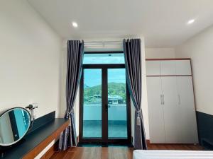 a room with a mirror and a large glass door at The Haven Motel in Chú Cư