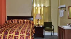 a bedroom with a bed and a chair and a sink at Desmond Hotel in San Francisco