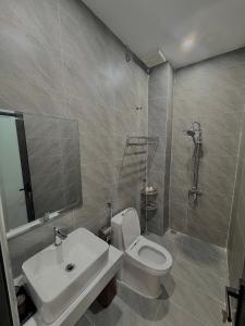 a bathroom with a toilet and a sink and a shower at The Haven Motel in Chú Cư