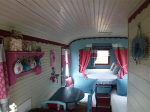 Habitación pequeña con cama en una casa de muñecas en La Petite Fadette, en Sancoins