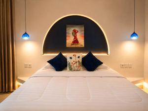a large white bed in a room with blue lights at Bnaya Villas Riverside in Amed