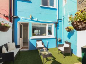 a blue building with chairs and a table in front of it at 1 Windermere in Kinvara