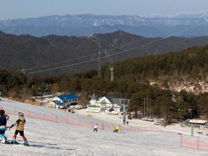 a group of people skiing down a snow covered slope at WhiteRunse in Takayama