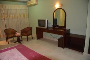a room with a desk with a tv and a mirror at Hotel City Inn in Chittagong
