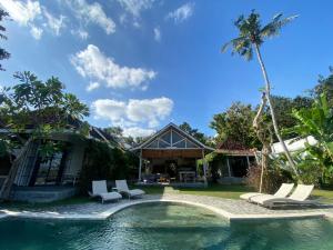 a villa with a swimming pool and a house at Sun Moon Star Villas in Jarakan