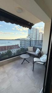 a living room with a couch and a table on a balcony at Perla Petrus in Rafailovici