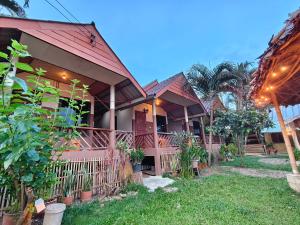 a house with a red roof and some plants at Pharit guesthouse in Pai