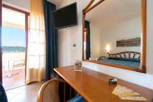a hotel room with a desk and a mirror at Albergo Le Briciole in Marciana Marina