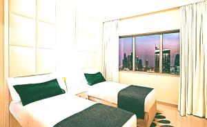 a hotel room with two beds and a window at Hotel- M8 in Kota