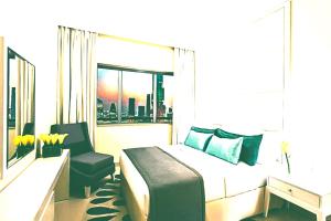 a bedroom with a bed and a chair and a window at Hotel- M8 in Kota
