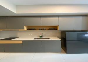 a kitchen with a sink and a refrigerator at Premium Taman Anggrek Residences in Jakarta