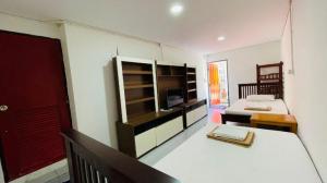 a room with a bedroom with a bed and a television at Super Hostel in Nonthaburi
