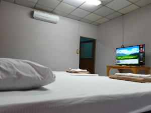 a bedroom with a bed and a flat screen tv at Super Hostel in Nonthaburi