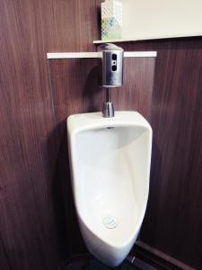 a urinal in a bathroom with a wooden wall at HOTEL LUCKY / Vacation STAY 4266 in Osaka