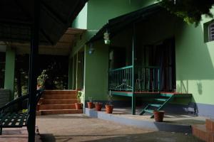 a green building with stairs and potted plants at The Chill Inn ''Families Only'' By Green Leaves in Ooty
