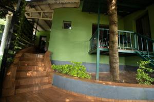 a building with stairs and a tree in front of it at The Chill Inn ''Families Only'' By Green Leaves in Ooty