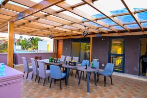 a patio with a table and chairs on a patio at Neon Hotel in Kampala