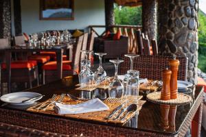 a table with glasses and utensils on top at Buffalo Safari Lodge in Katunguru