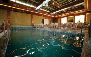 a large swimming pool in a large room with tables and chairs at Kabul Star Hotel & Restaurant in Shīrpūr