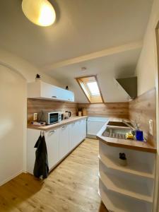 a kitchen with white cabinets and a sink at Gemminger Gasthaus in Gemmingen